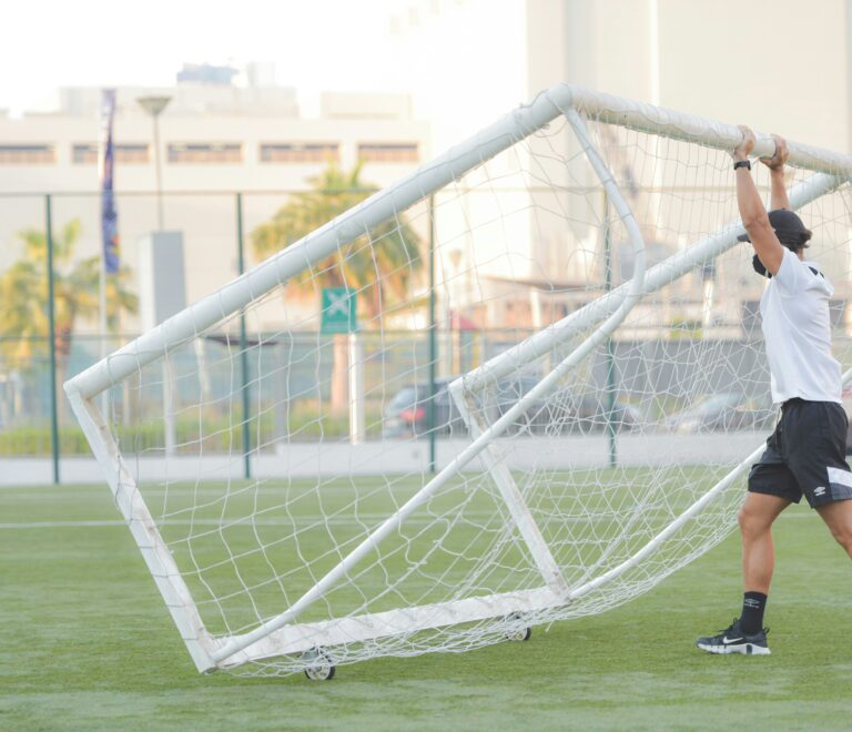 coach setting up goals on field