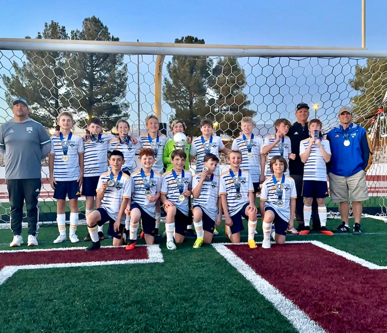 Scott Bloomfield's boys soccer team standing in front of a goal