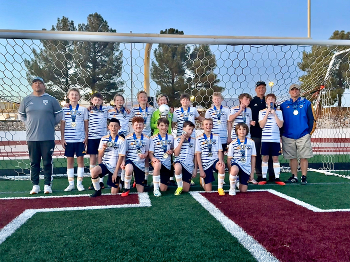 Scott Bloomfield's boys soccer team standing in front of a goal